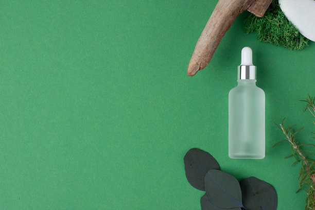 化妆瓶与木材和苔藓在绿色自然背景。平铺，复制空间。图片下载
