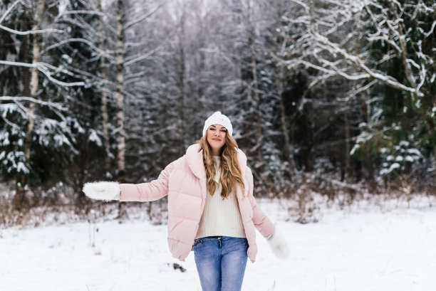 有趣的现场照片，一个女孩在雪地公园散步，她的手臂向不同的方向伸展图片下载