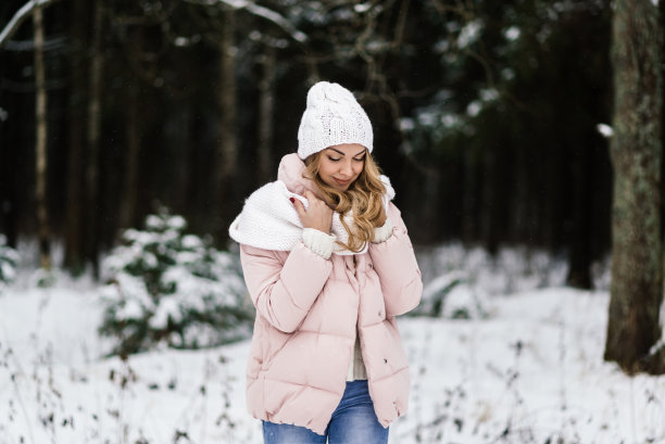 一个年轻的微笑美丽的女人在一个下雪的公园的现场照片图片下载