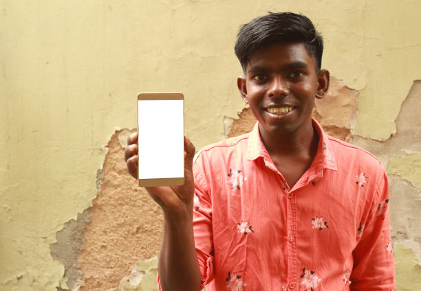 年轻的印度男子展示他的智能手机图片下载