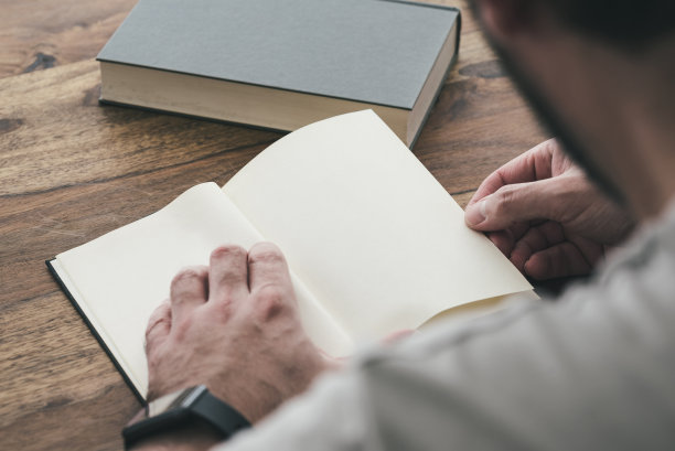 坐在木桌上看书的人图片下载