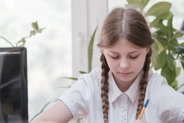 女学生的肖像享受学习在共享办公室使用笔记本电脑做研究，自由职业者在做项目，远程工作做笔记。小学生集中绘画笔记图片下载