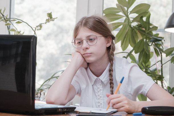 女学生的肖像享受学习在共享办公室使用笔记本电脑做研究，自由职业者在做项目，远程工作做笔记。小学生集中绘画笔记图片下载