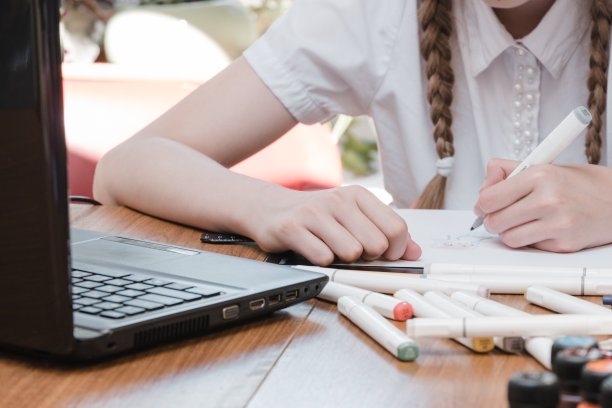 女学生的肖像享受学习在共享办公室使用笔记本电脑做研究，自由职业者在做项目，远程工作做笔记。小学生集中绘画笔记图片下载