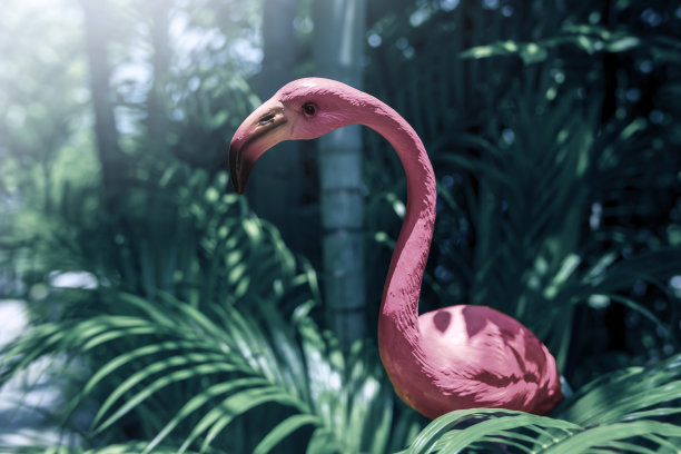 充满活力的粉红色火烈鸟雕塑和树叶装饰花园图片下载