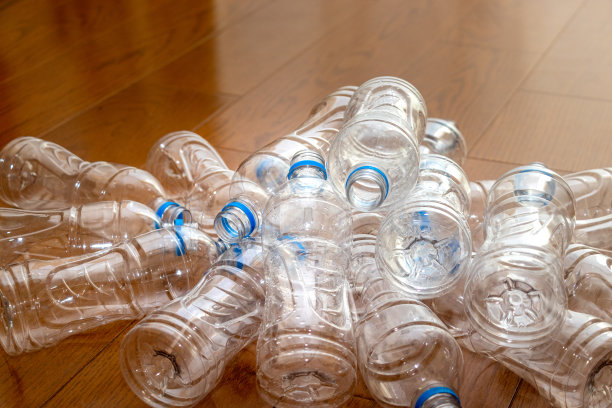 地板上凌乱地堆放着许多空塑料瓶图片下载