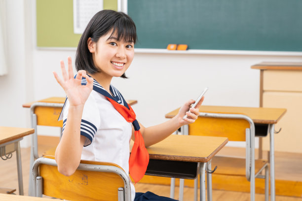 亚洲女学生在教室里学习，智能手机，制服，图片下载