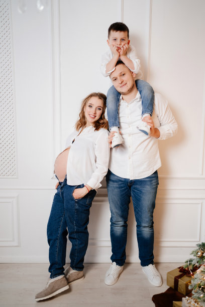 幸福的家庭。怀孕的母亲和她的儿子和穿着牛仔裤和白衬衫的父亲图片下载