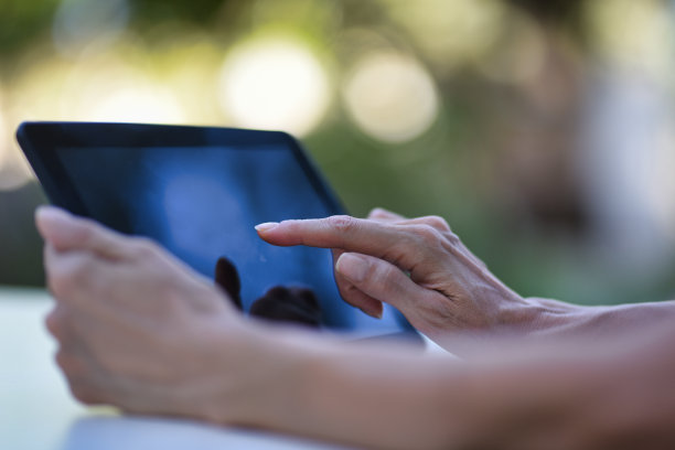 女人的手在户外使用电子平板电脑图片下载