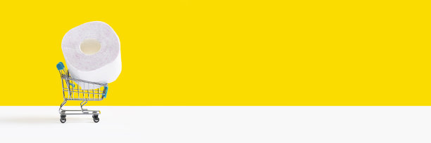 玩具购物车或手推车，大卷卫生纸孤立在黄色背景上。销售的概念。带有复制空间的长横幅图片下载