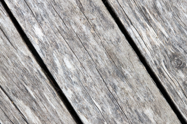 旧的风化水洗污染的木材纹理与对角裂缝和树枝。自然纹理的特写干木板背景。图片下载