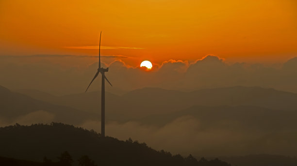 日出从风车旋转的山顶升起图片下载