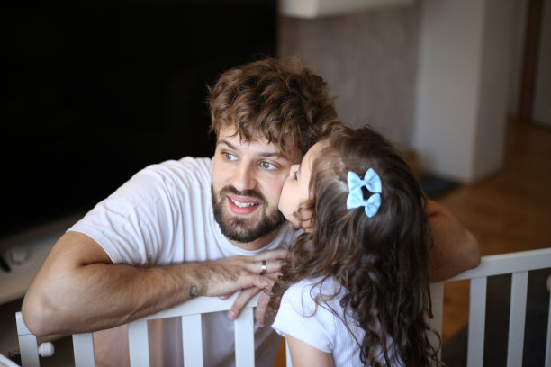 父亲和女儿在拍一张婴儿床照片图片下载
