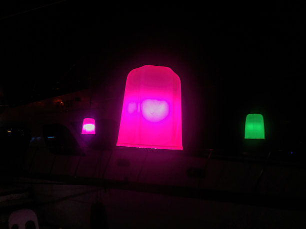 紫色和绿色的灯泡在黑暗中悬挂在屋顶上图片下载