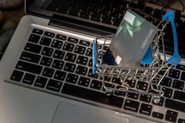 迷你超市购物车里的信用卡和笔记本电脑键盘。图片下载