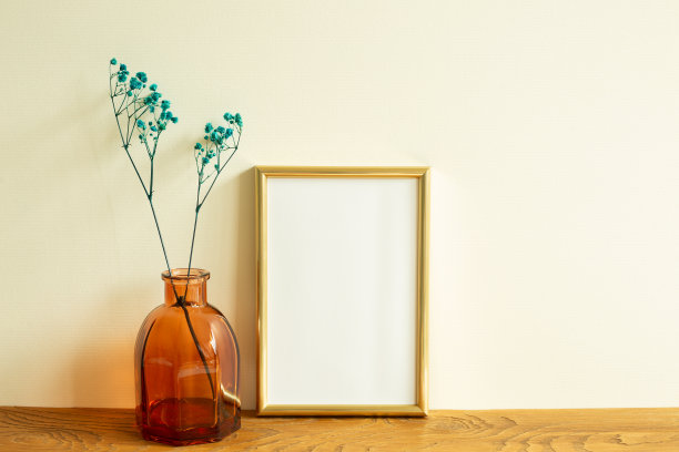 金质相框，木桌上摆着干花。米色背景墙。室内设计图片下载