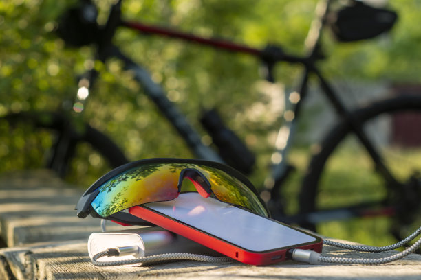 移动银行在森林里以自行车为背景给智能手机充电。图片下载