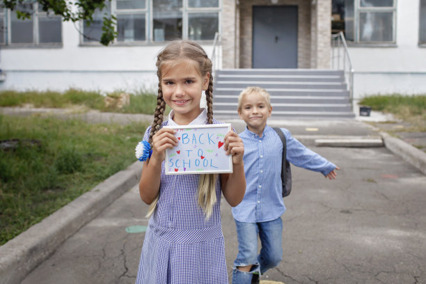 女孩拿着照片和回到学校的信息，男孩背着书包跑步后，第一天离线图片下载