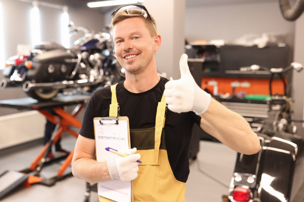 熟练的修理工拿着带有文件的剪贴板，并向汽车车间竖起大拇指图片下载