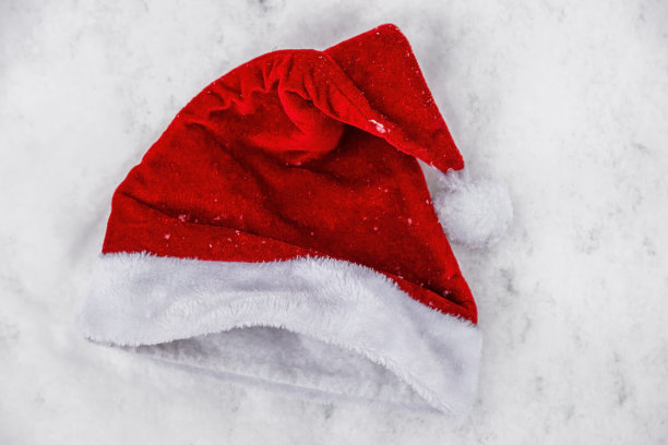 圣诞老人的帽子在雪地里被遗弃或遗忘图片下载
