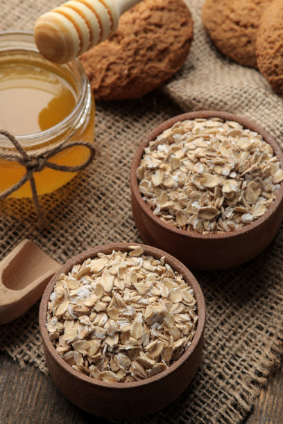 干燕麦片，蜂蜜和燕麦饼干。食物。健康食品。在一张棕色的木桌上。图片下载