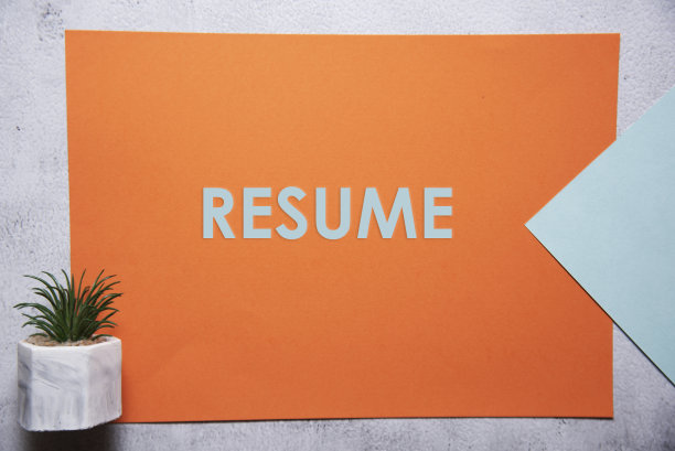 简历文本在橙色和淡蓝色的背景平lay概念。图片下载