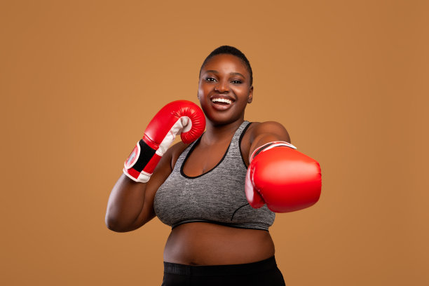 一名年轻的黑人女子在演播室里戴着拳击手套图片下载
