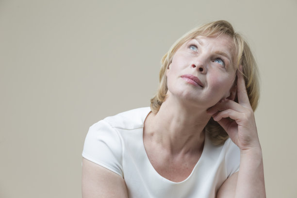 白种人金发女人在休闲服装与举起的手在米色背景下思考。水平的形象图片下载