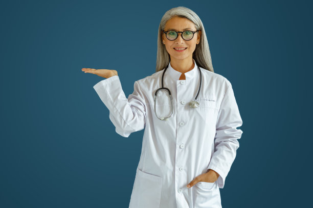 画室里，一位中年女医生，戴着眼镜，拿着听诊器，在蓝色背景旁指着一边图片下载