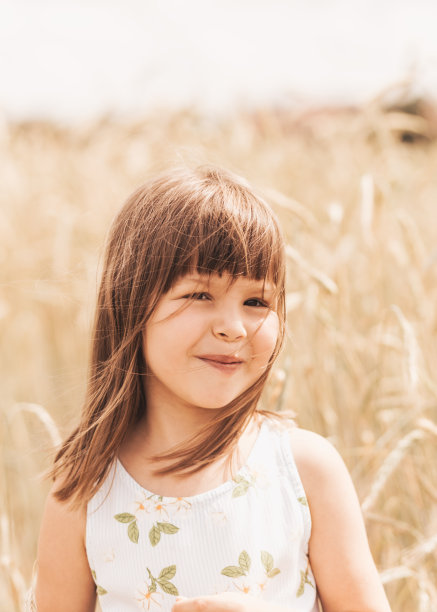 一个微笑的小女孩的特写照片在夏天的大自然中金发碧眼图片下载