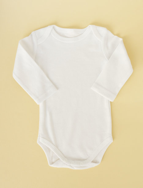 白色的婴儿服放在黄色的背景上，平躺着。模型设计图片下载