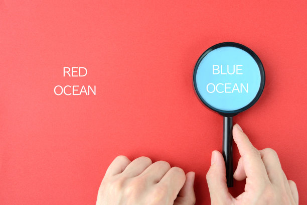 商人的双手用放大镜发现蓝色的海洋图片下载