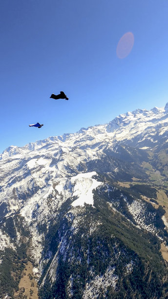 身穿翼装的飞行员在晴朗的天空中滑翔图片下载