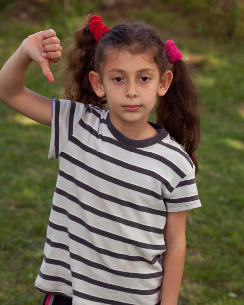 一个小女孩在后院竖大拇指的照片图片下载