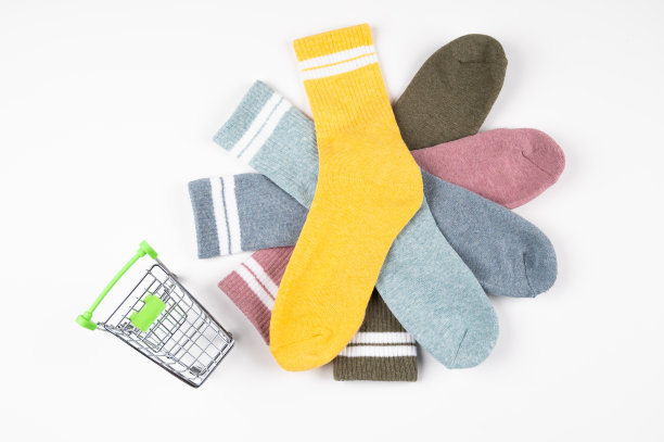 购物车和一堆多色的袜子孤立在白色上。消费者购物的概念图片下载