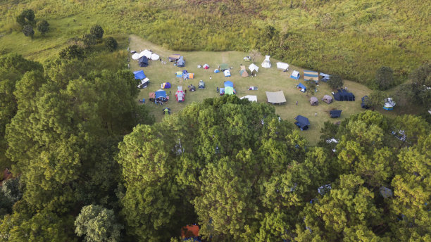 俯瞰日落时绿色草地上的游客帐篷。露营的背景。旅游概念图片下载