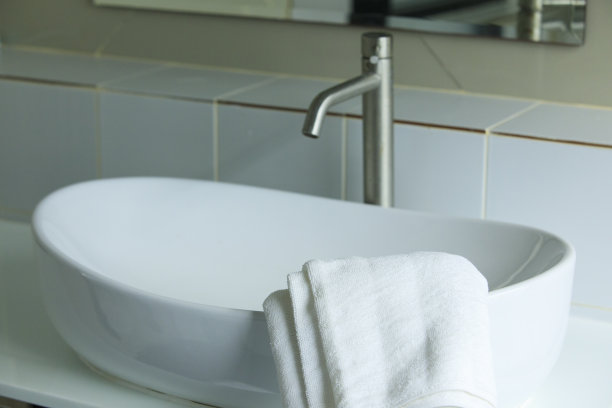 浴室里的洗脸盆上有毛巾，淋浴设备图片下载