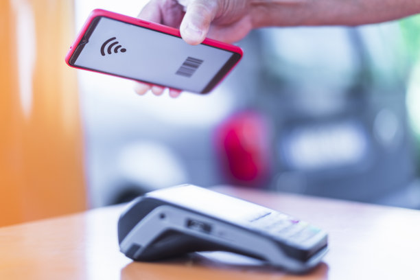 一名男子在加油站用智能手机进行非接触式支付素材图片