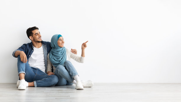 戴着头巾坐在地板上和丈夫在一起的梦幻女人图片下载