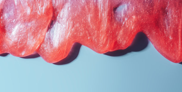 红色黏液在蓝色背景上流动图片下载