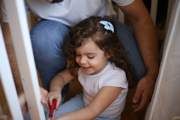 父亲和女儿在拍一张婴儿床照片图片下载