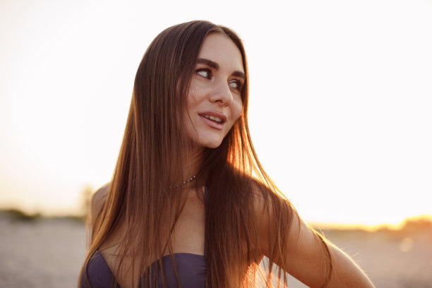 年轻迷人的女人穿着比基尼在海滩上的照片图片下载