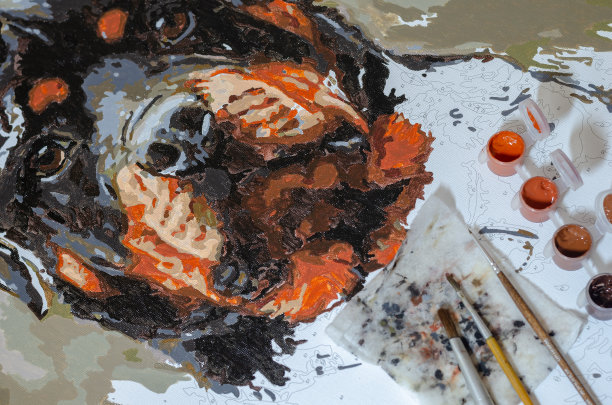 未完成的罗特韦尔犬画像和画布上的画笔。图片下载