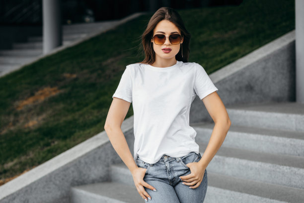 时尚的黑发女孩穿着白色t恤和眼镜对着街道，城市服装风格。街头摄影图片下载