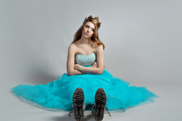 现代的公主，戴着王冠，穿着华丽的蓝色裙子和运动鞋的美女，图片下载