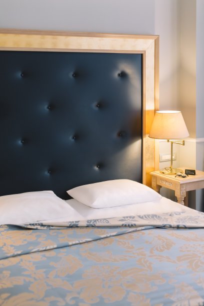 垂直照片的双人床与白色枕头和床头柜在豪华酒店。图片下载