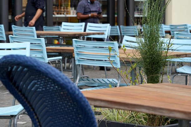 户外餐厅，空着桌椅。背景中有等候客人的服务员。来自瑞士卢塞恩老城的城市风景，在罗伊斯河岸边。图片下载