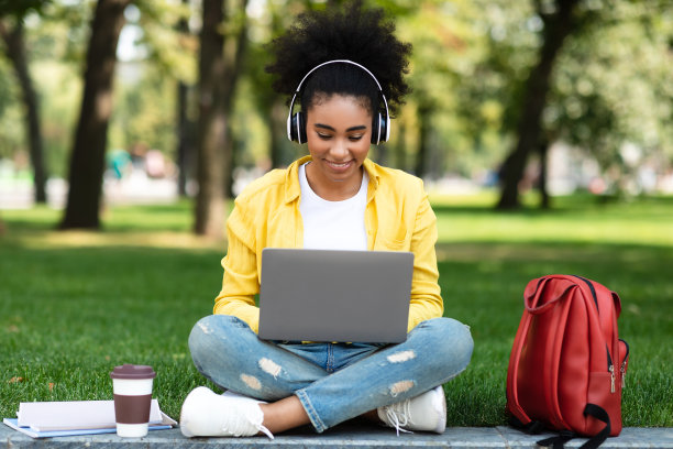 黑人女学生在公园用笔记本电脑上课图片下载