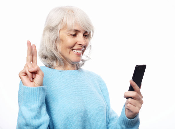 祖母在电话里和她的孙子们聊天，微笑着和他们打招呼图片下载