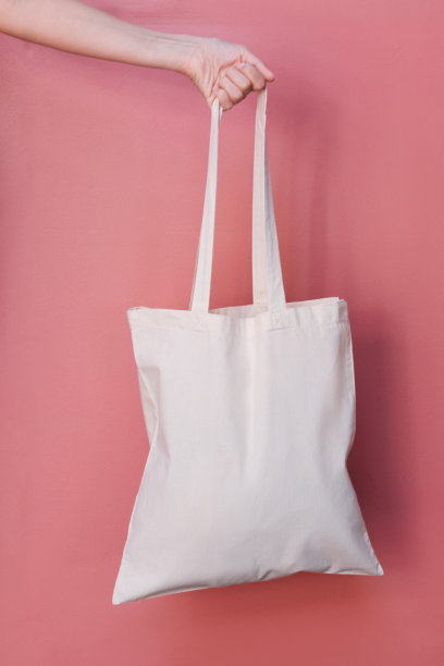 白色手提袋在粉红色的垂直背景。图片下载
